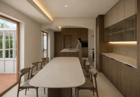 芦屋市六麓荘リノベーション。明るい天板のダイニングテーブルと木目の収納。アーチ状の開口の奥にキッチンを配置。