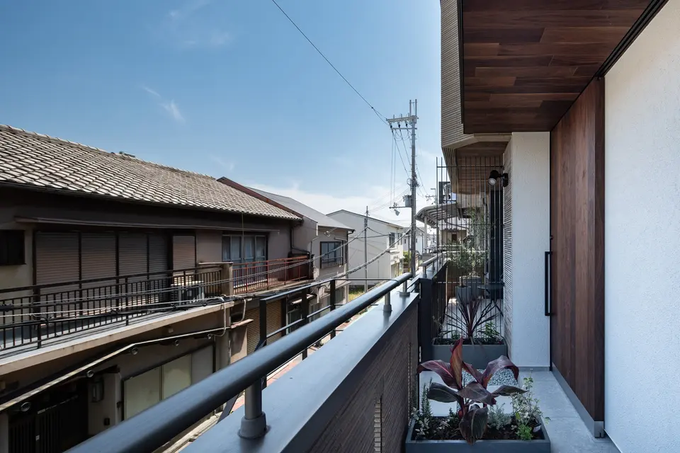 岸和田のリノベーション。植栽を配した2階の玄関アプローチと木張りの軒天