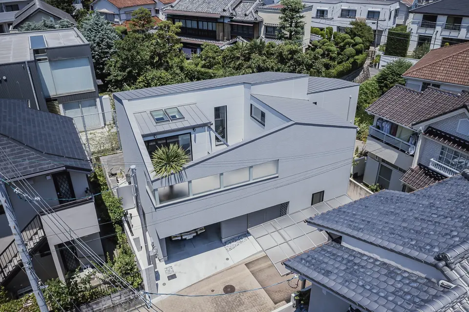 宝塚のライトコートハウスの全景。周囲を住宅に囲まれた敷地に、中庭と天窓を設けた建物を上空から望む。